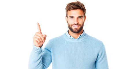 Fototapeta premium A smiling man in a light blue sweater raises his index finger, suggesting a point or idea.