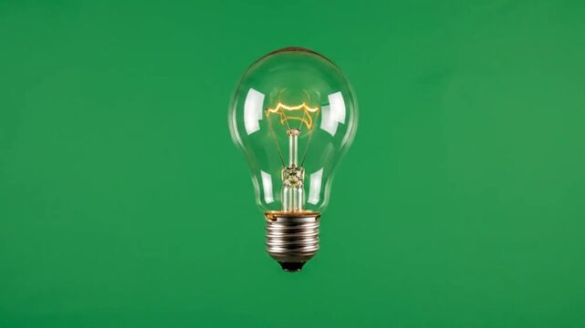 Brightly glowing incandescent light bulb centered against a vibrant green background, symbolizing a brilliant new idea, creative inspiration, or innovative thought process