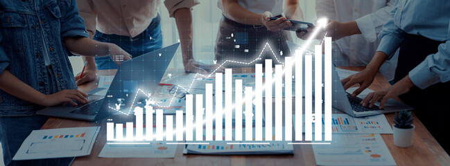 Team members collaborate in a modern office setting, analyzing growth metrics and data trends through digital charts and graphs to drive strategic decisions. Axiom