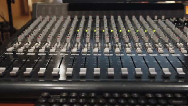 Detailed view of audio fader array with illuminated level indicators