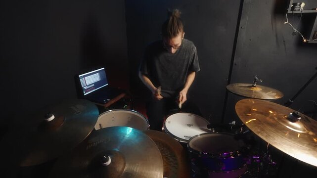 Musician concentrates on accuracy with backing track during session