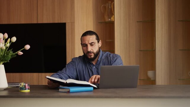 Diligent Arab male student preparing for exams at home, distance learning