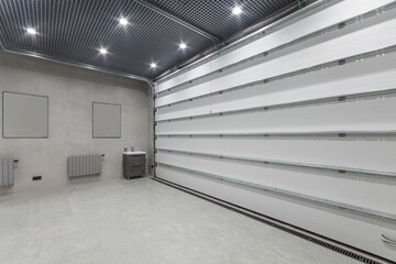 Spacious private garage with automatic gates. A bright room decorated with tiles. A sink with a...