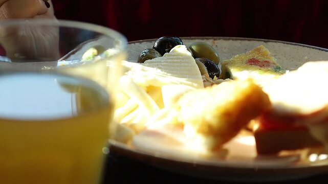 A plate of assorted pastries and cheese arranged on a formally set restaurant table. evokes a sense of indulgence, hospitality, and leisurely dining.