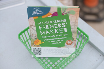 Naklejka premium green plastic fruit basket with postcards at Allan Gardens Conservatory, Toronto