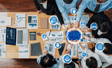 A diverse team collaborates over statistical data and business graphs, showcasing teamwork in a modern office environment with digital insights for improved decision-making. Amity