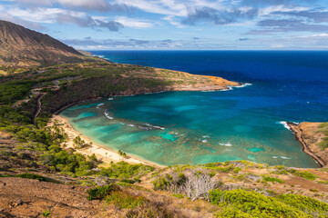 Obraz premium Coastal landscape overlooking Honamula Bay in Hawaii with turquoise ocean water, rocky shoreline, and tropical vegetation in a scenic island environment.