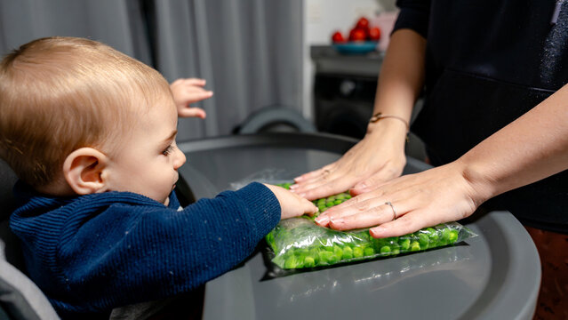 Baby sensory exploration with green peas