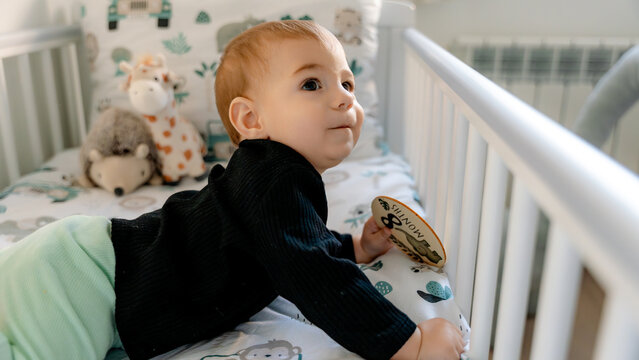 Baby in crib holding 8-month milestone card
