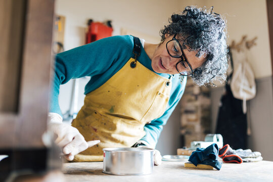 Woman restoring furniture in workshop