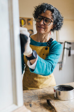 Woman restoring furniture in a workshop setting
