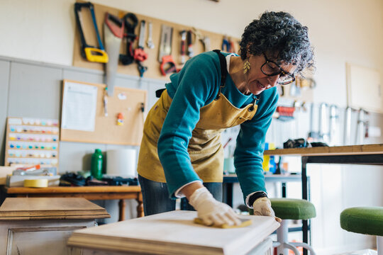 Woman restoring furniture in a workshop setting
