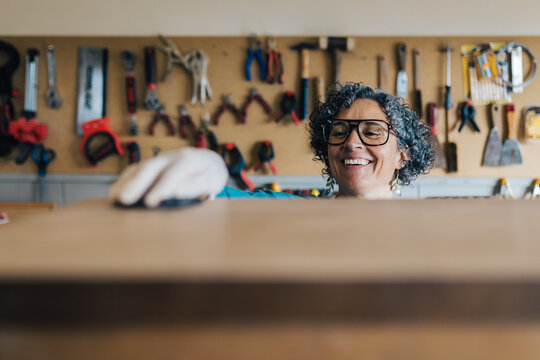 Woman restoring furniture in a workshop setting