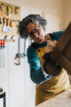 Experienced restorer carefully refinishing wooden furniture