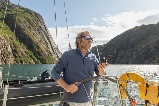 Sailor navigating fjord in Norway's Lofoten Islands