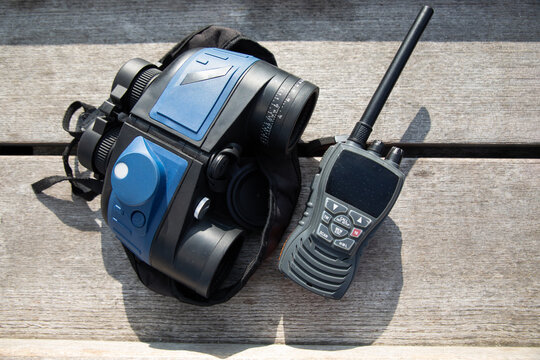 Binoculars and radio communication gear on wooden bench