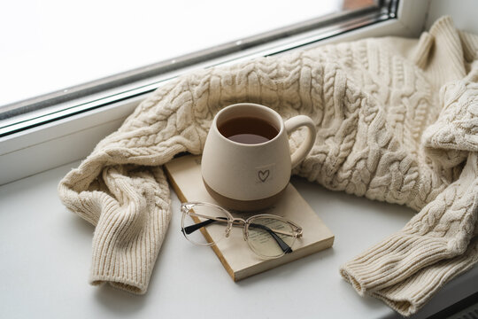 Cozy afternoon tea by the window with book and glasses