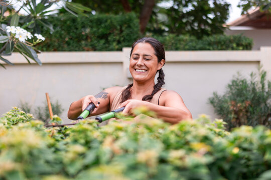Woman gardening outdoors with pruning shears