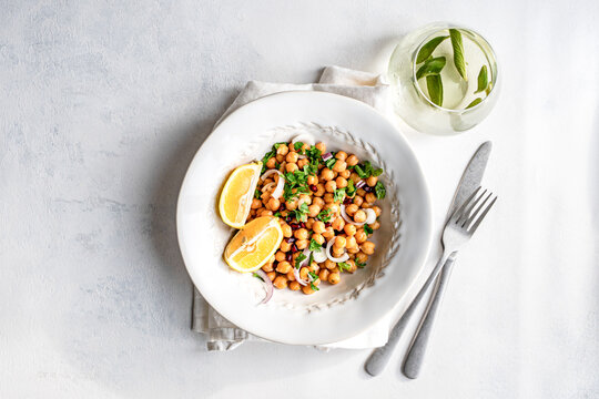 Chickpeas salad with sage lemonade on white table