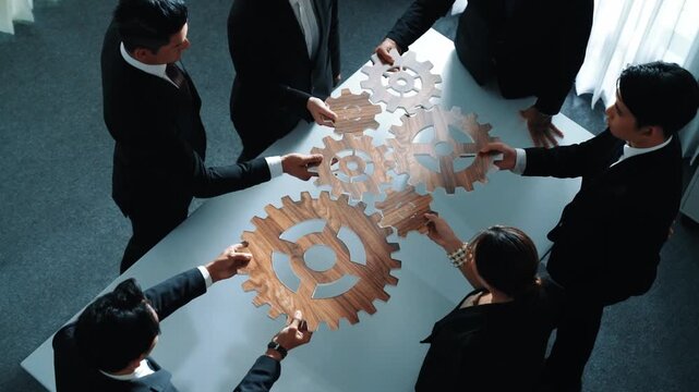 Top view of smart business people gather wooden cog together at meeting. Group of project manager helping and team working to solve problem at meeting room or workplace. Represent unity. Directorate.