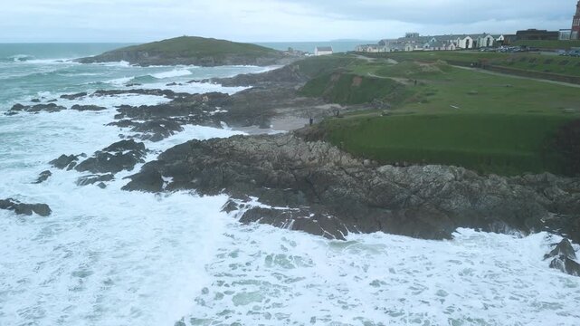 drone shot of tourists looking out from headland North Fistral beach at cornwall cliffs at newguay 