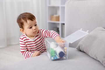 Naklejka premium Child safety at home. Little boy with box of pills indoors