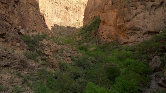 Aerial drone view of Apache Trail canyon near Phoenix Arizona with red rock and green vegetation.
