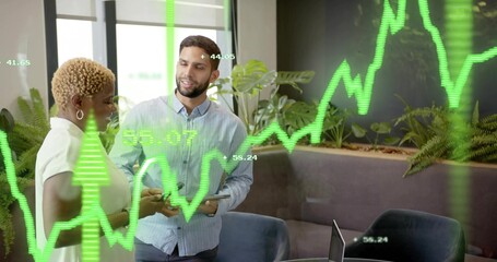 Discussing team in shirts analyzing green chart on glass wall at office lounge, tablet smartphone