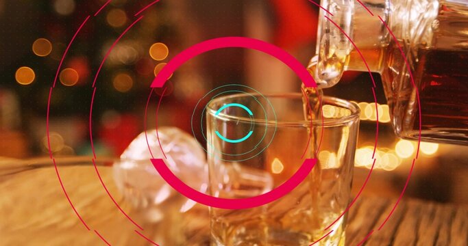 Pouring bottle filling short tumbler on wooden table, with ice sphere ornament and magenta overlay