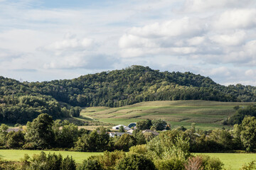 Fototapeta premium Rural Farm Valley with Rolling Hills and Patchwork Fields
