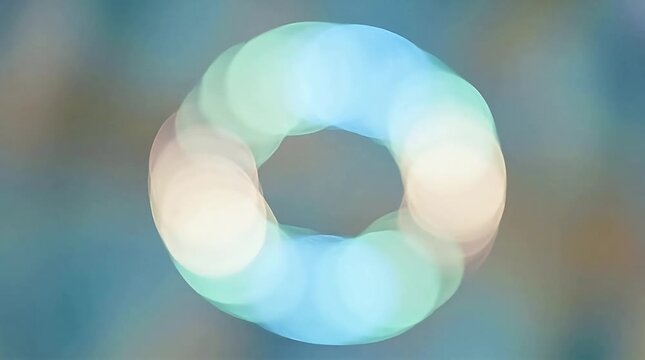 A serene, abstract ring-shaped formation glows softly against a blurred, multicolored background, viewed from a straightforward perspective.