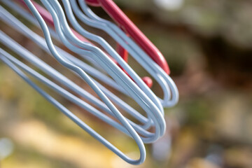 Row of plastic clothes hangers on rack, close up photo with blurred background bokeh