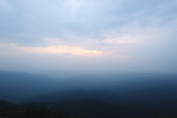 Obraz premium Moody Mountain Landscape at Dawn with Heavy Blue Mist and Foggy Horizon