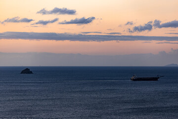 sunrise over the sea with barge and island 
