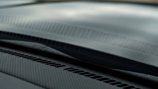 Close-up of a car's hood with carbon fiber texture and vents.
