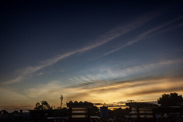 Sunset over the city with silhouette of the roof of the house