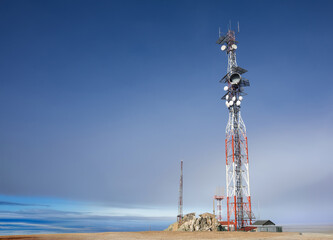 Telecommunications Tower with Radio Dishes Against a Deep Blue Sky