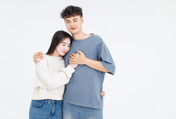 Fototapeta premium Portrait asian cute young couple love happy cheerful smile posing embracing in casual clothes hugging on white background studio together relationship good time sweet enjoy moment beautiful romantic.