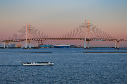 横浜港、夕焼けに染まるベイブリッジと行きかう遊覧船
