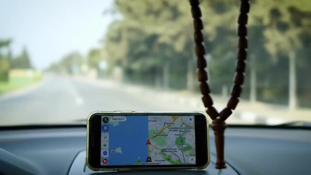 Cinematic 4K Footage of Muslim Prayer Beads (Tasbih) Hanging in Car Dashboard While Driving on Road Using GPS Navigation