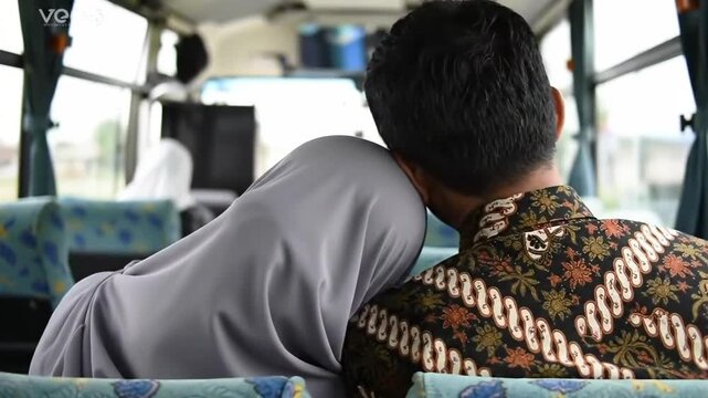 Emotional 4K Video of a Muslim Couple Traveling Home on a Bus, Resting Together during Long Ramadhan or Eid al-Fitr Journey