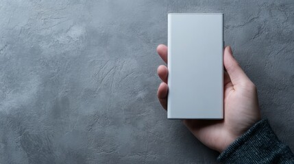 Human hand holding sleek white smartphone featuring pristine blank screen for content display.