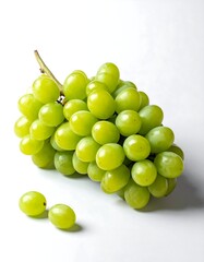 A cluster of green grapes with two loose grapes