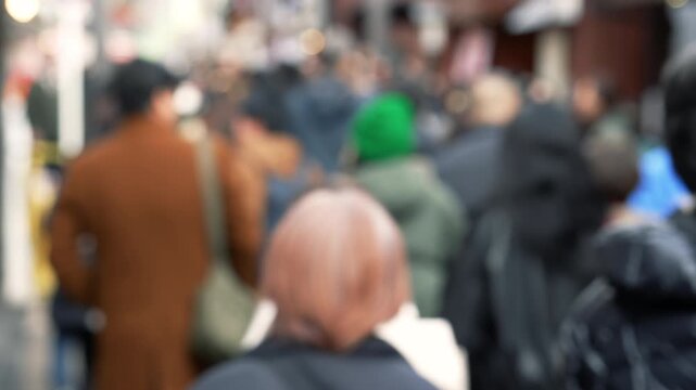 Defocused urban crowd walking in a brown-toned Tokyo street setting.