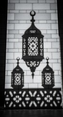 Obraz premium Elegant Ornate Lantern Shadow Projection on White Brick Wall in Low Light Setting