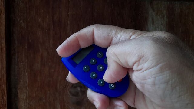 Close up video of a human hand pressing numeric buttons on a banking security token, representing digital authentication, online banking safety, financial technology, secure transactions