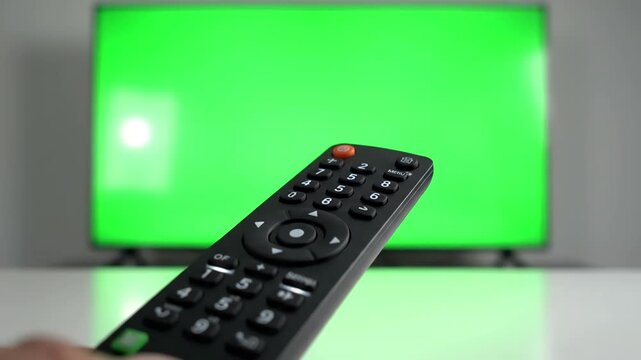 Remote Control Interaction with person pointing a tv and pressing buttons in front of green screen distortion, overlay, glitch, static noise, scan lines on black background, 4k animated video loop