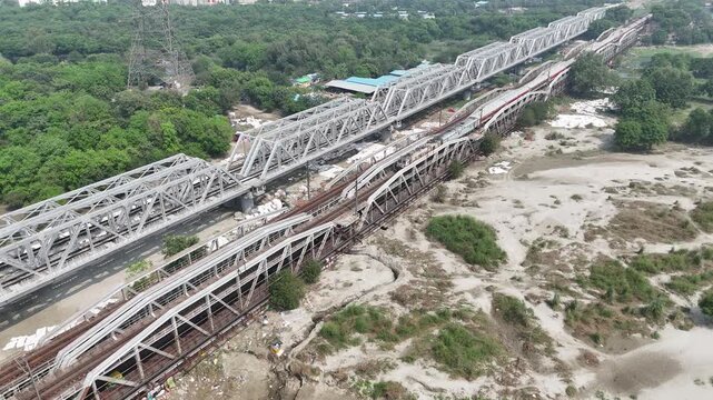 Aerial view of old iron bridge, Loha pul at Yamuna River in Delhi, Train is going on the bridge
