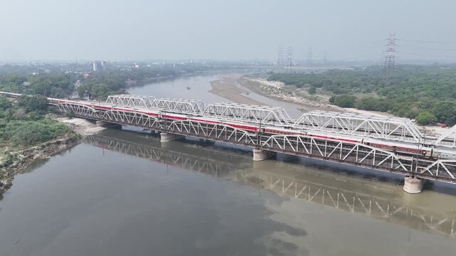 Aerial view of old iron bridge, Loha pul at Yamuna River in Delhi, Train is going on the bridge

