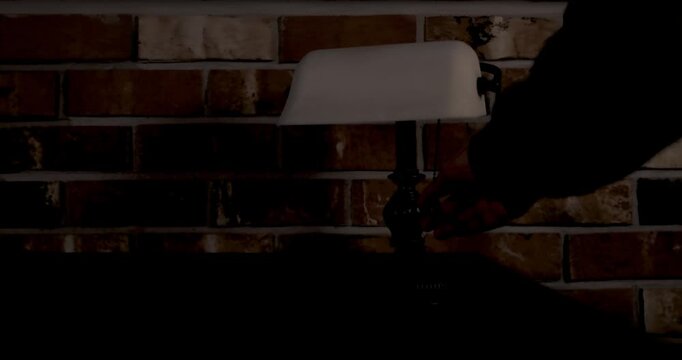 Warm lamp light turning on in a dark interior, creating a calm and cozy atmosphere. The scene symbolizes comfort, safety, relaxation, and the transition from darkness to light.